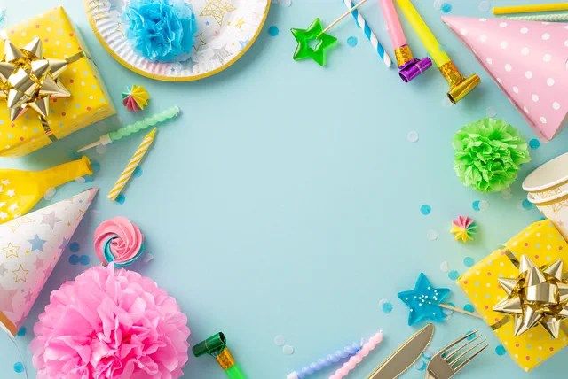 Party hats, gifts and streamers framing a blue table