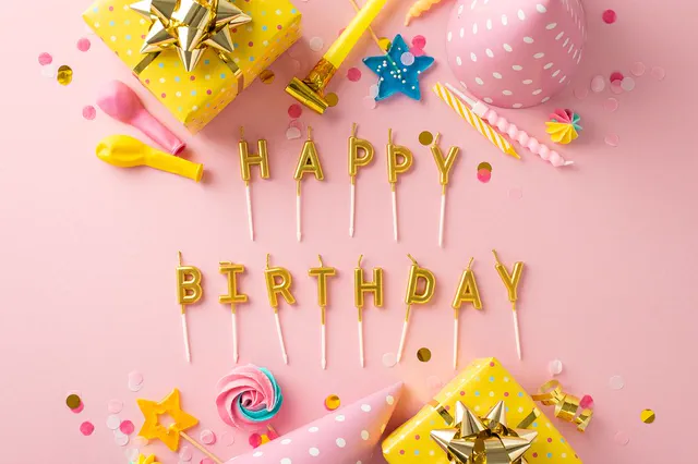 Gold Happy Birthday candles on pink with gifts