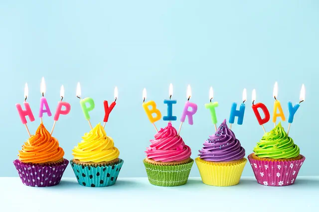 Rainbow cupcakes with Happy Birthday letter candles