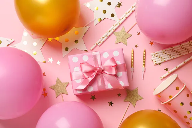 Pink gift box with balloons and gold stars