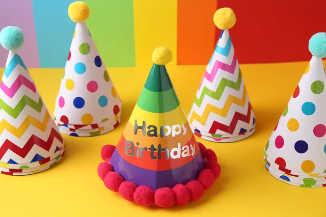 Colorful party hats with a Happy Birthday hat in front