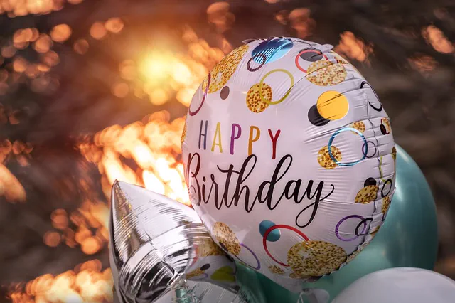 Happy Birthday foil balloon with warm bokeh lights
