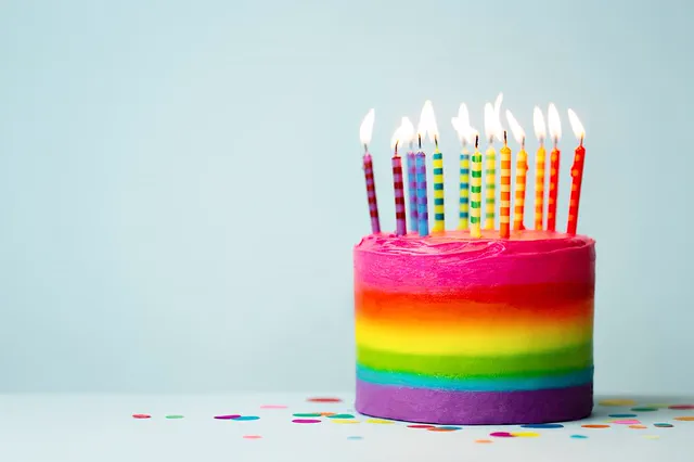 Rainbow layer cake with tall birthday candles