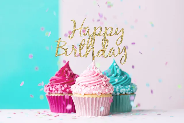 Pink and teal cupcakes with a gold Happy Birthday topper