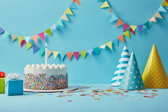 Sprinkle cake under colorful bunting with party hats